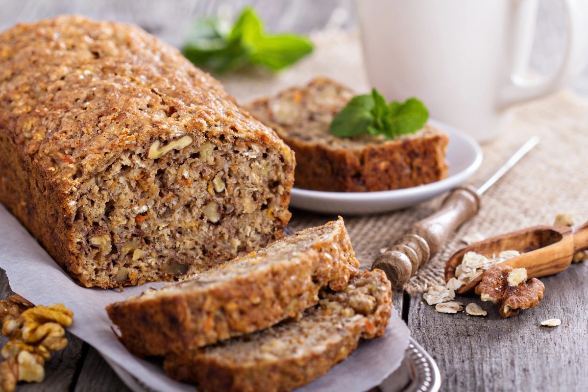 Freshly baked banana bread on a wooden table, perfect for a work snack