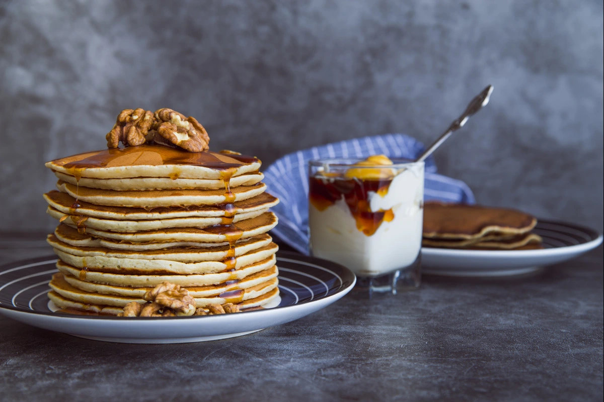 Stack of fluffy homemade pancakes with syrup and fresh berries